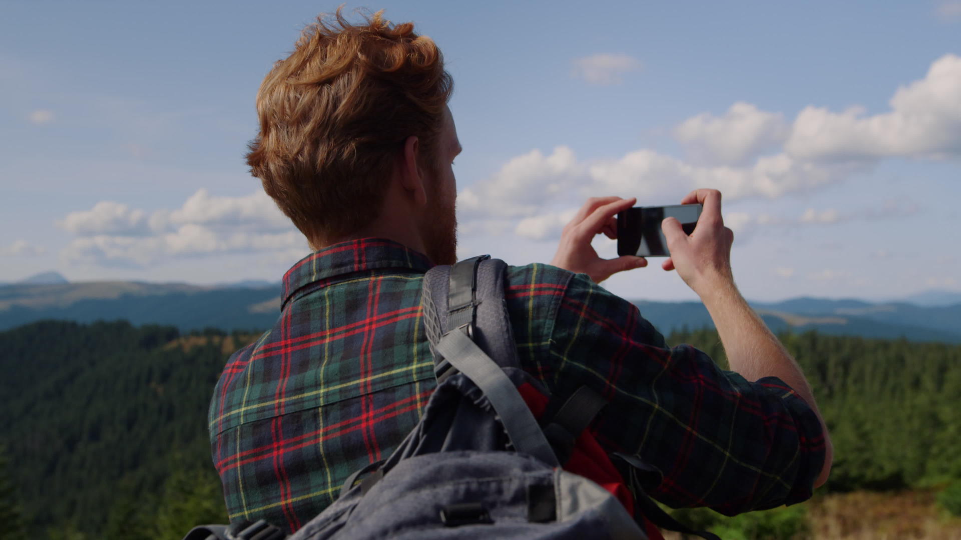 男性摄影师在山顶拍摄视频的预览图