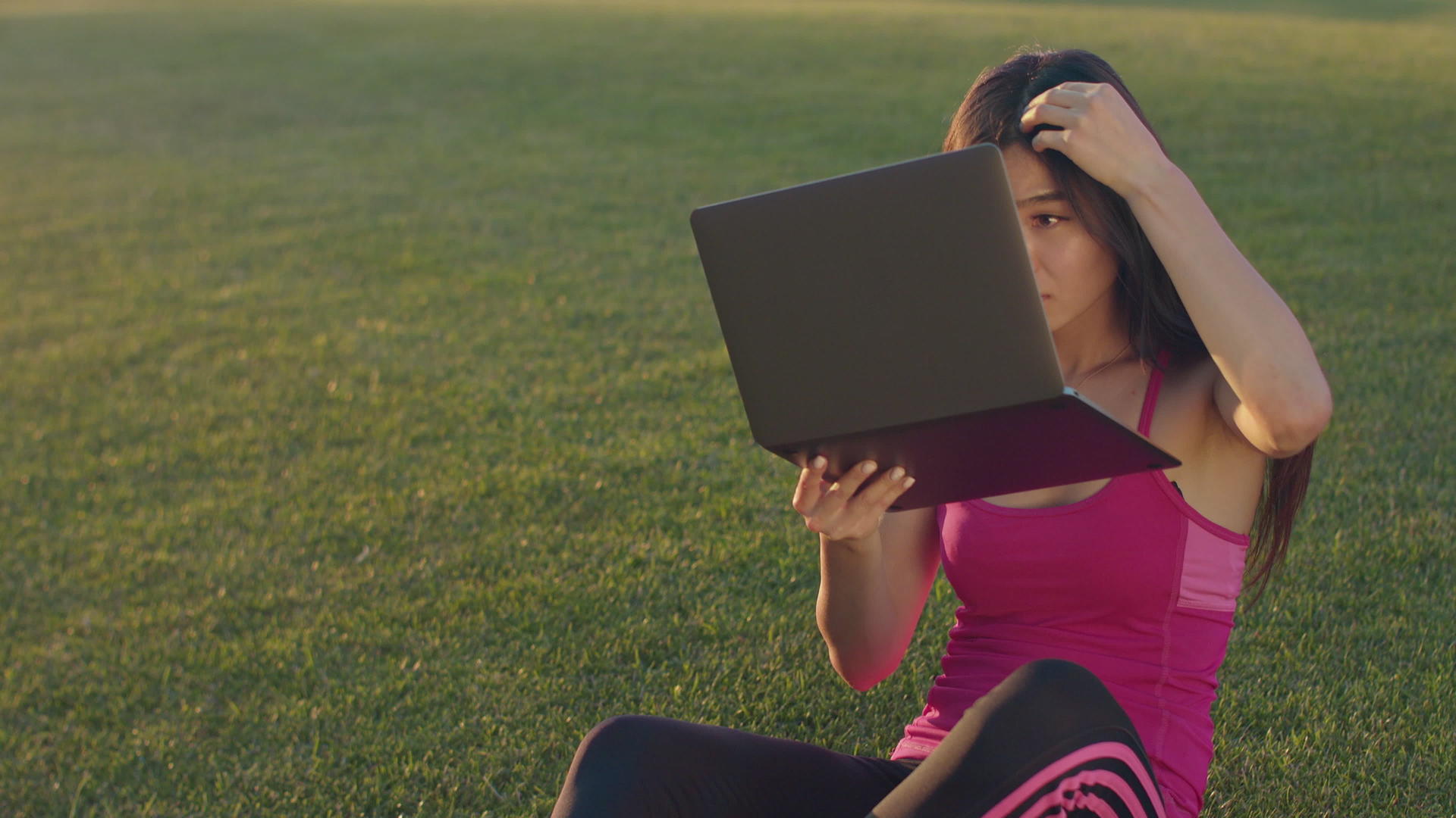 女性在公园草坪上用电脑办公视频的预览图