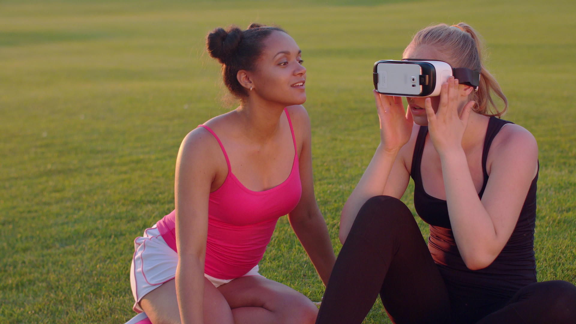 公园草坪上有两个年轻女性VR设备视频的预览图