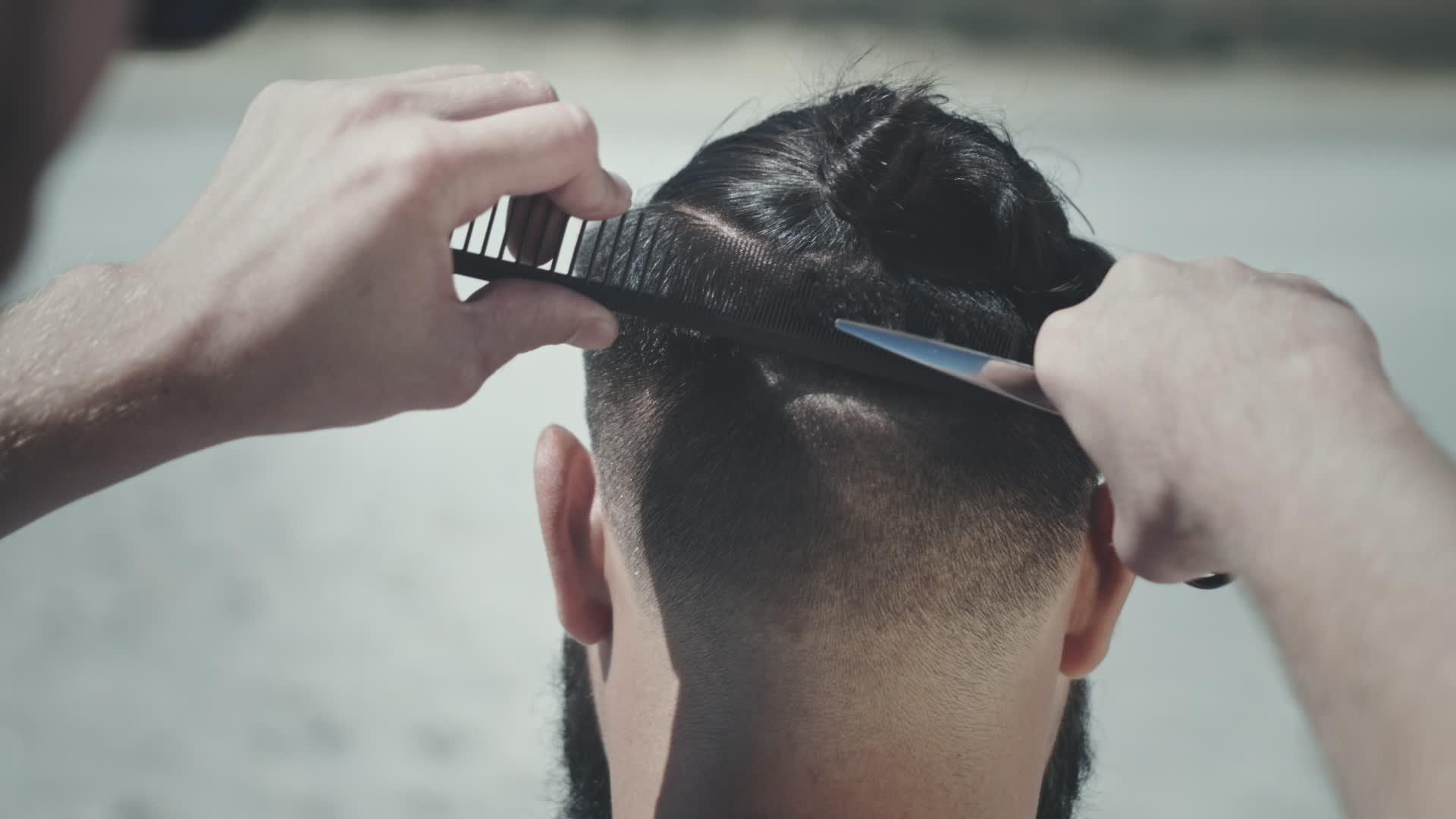 理发师的第一个视角是修剪男性顾客的头发视频的预览图