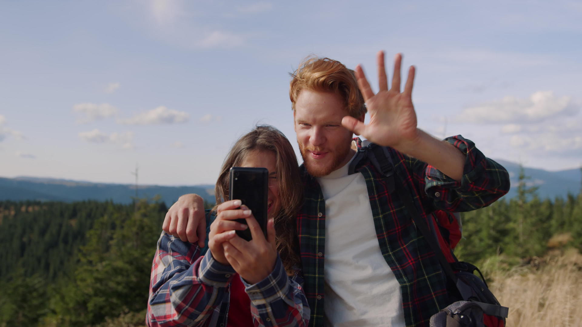 山顶上的恋人依偎在一起用手机自拍视频的预览图