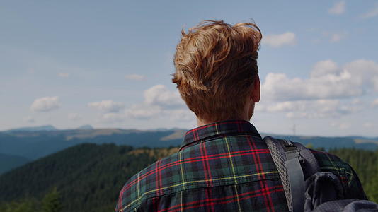 金发男孩在山顶俯瞰远处视频的预览图