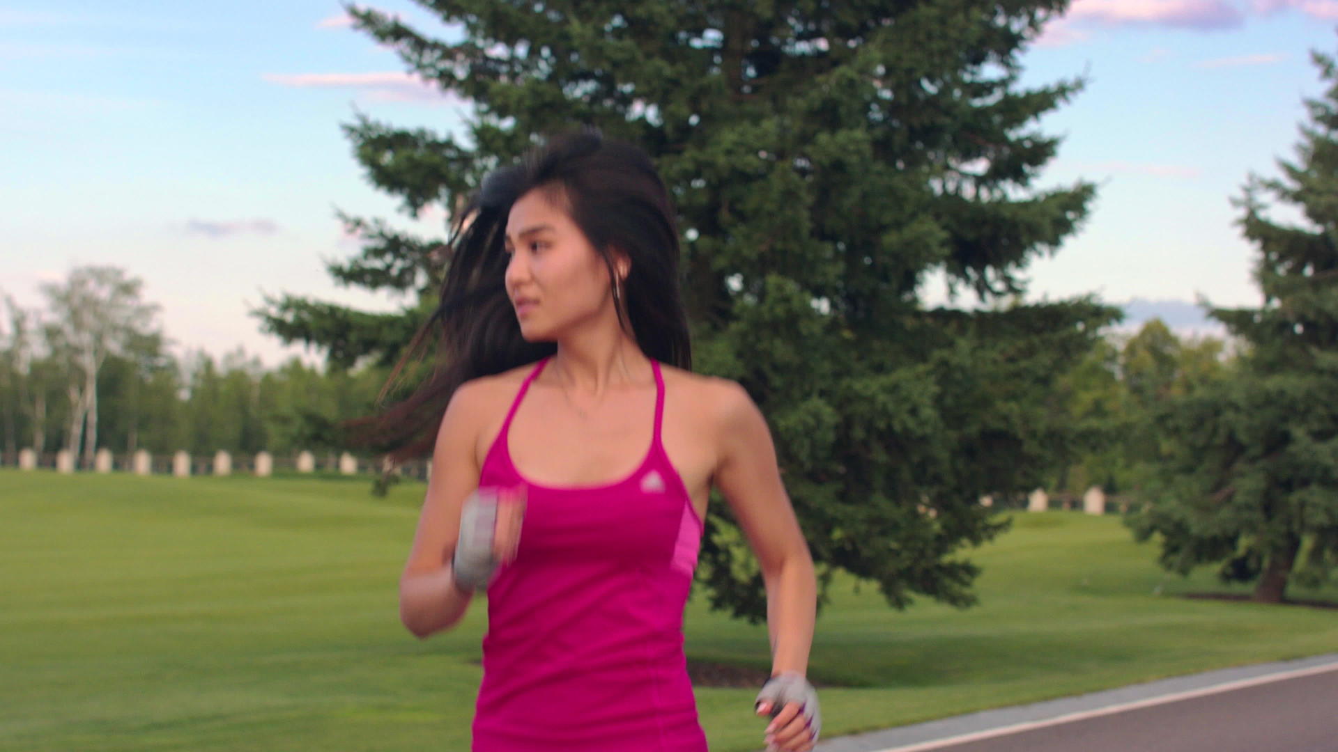 紫红色运动服女孩在公园里跑步视频的预览图