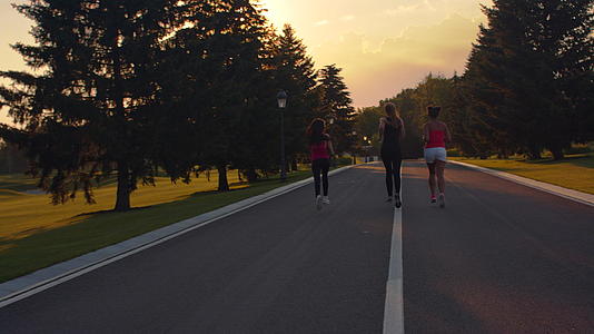 三个女孩在早晨的日出公园里跑步和锻炼视频的预览图