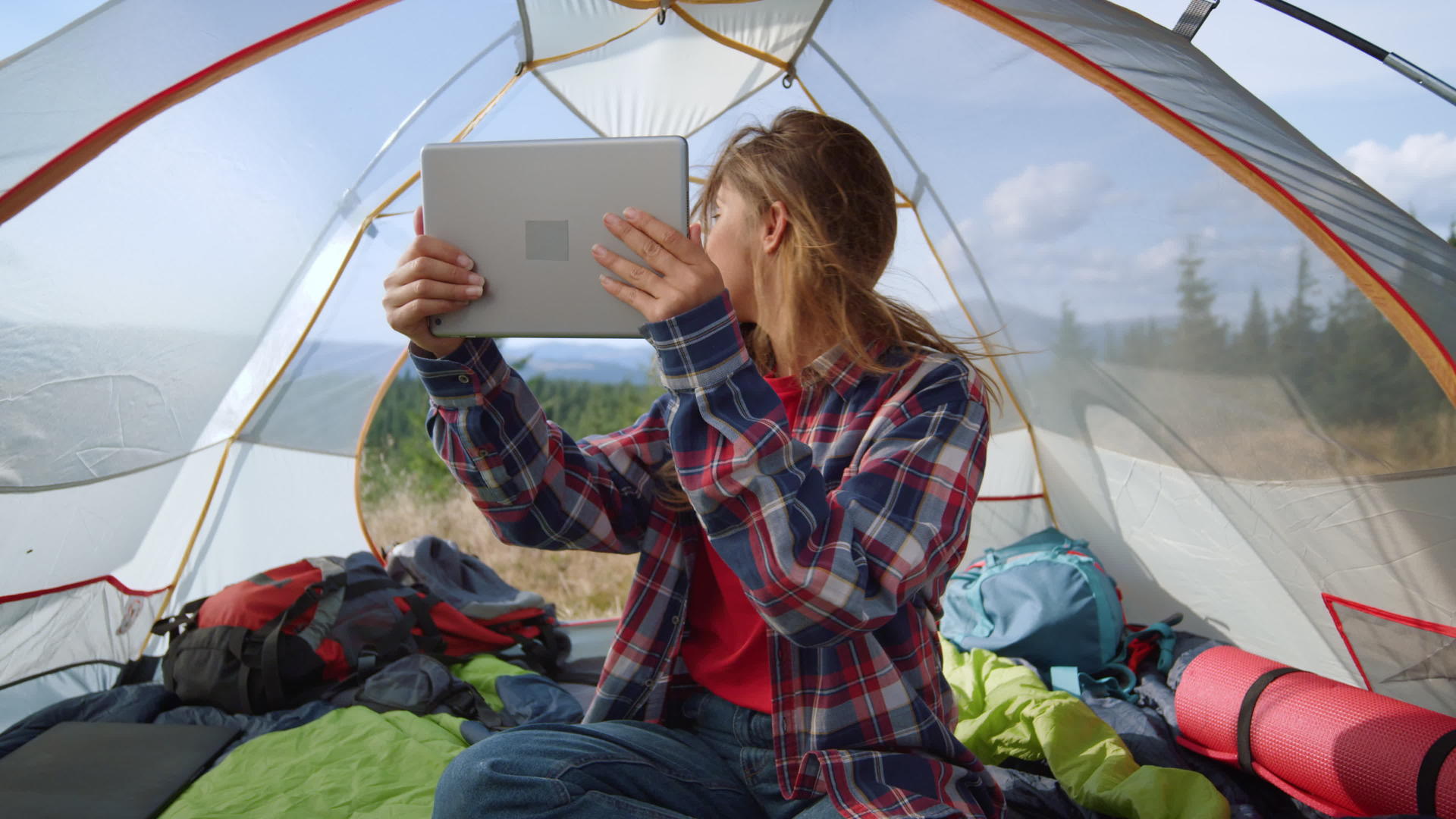 女孩在帐篷里看ipad视频的预览图