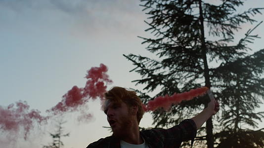 男人在树林里点燃烟雾视频的预览图