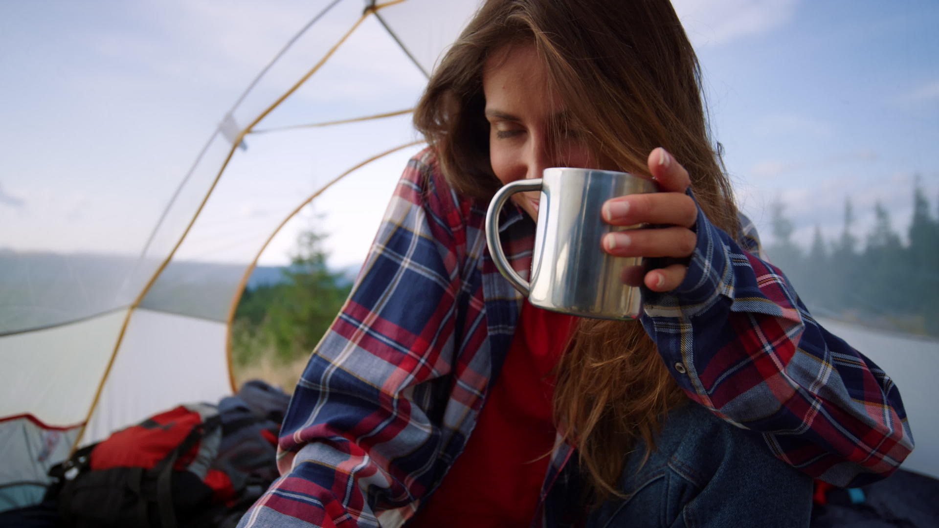女孩拿着不锈钢水杯在帐篷里喝水视频的预览图