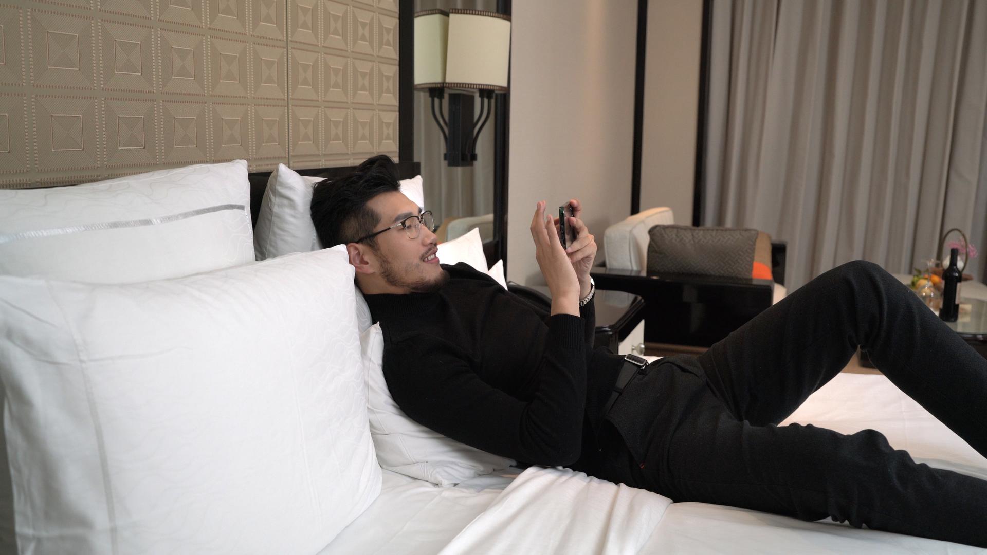 酒店床上的商务男性打游戏视频的预览图
