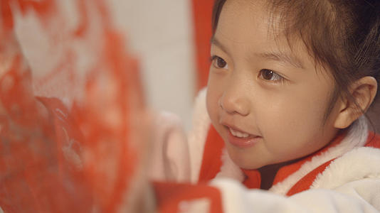4K小女孩春节贴窗花装饰视频的预览图