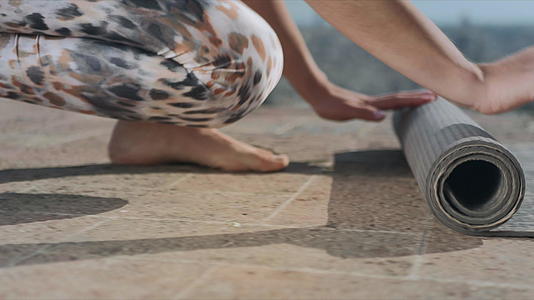 女性户外运动后在健身垫上滚瑜伽教练折叠床垫视频的预览图