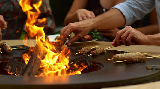 男人在后院的烧烤炉上做肉和小吃男厨师烧烤视频的预览图