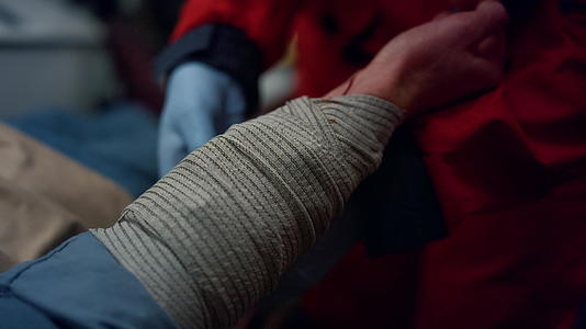 急救护理人员将患者的手和弹性绷带包裹在手套上视频的预览图
