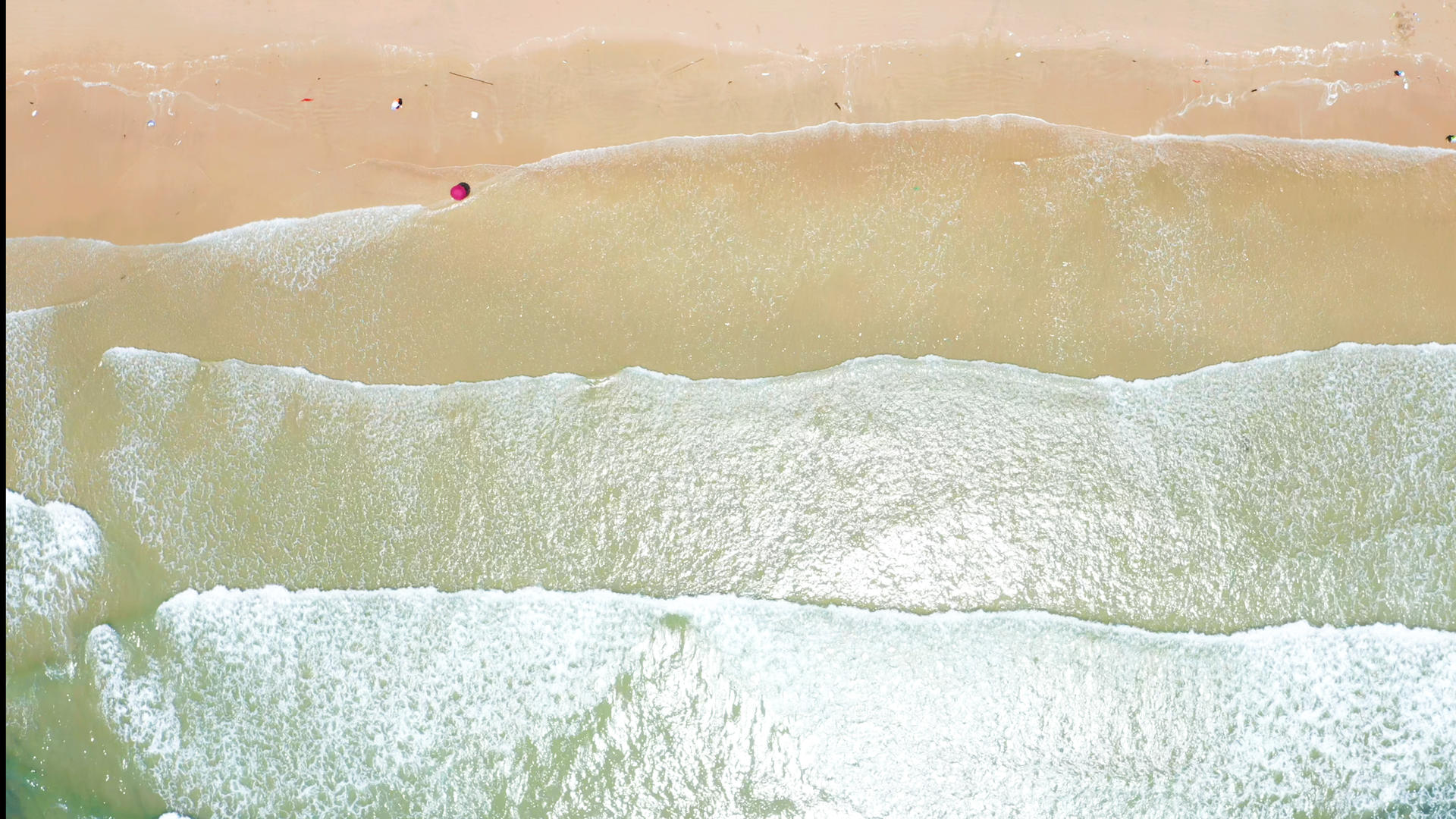 俯拍沙滩上的海浪视频的预览图