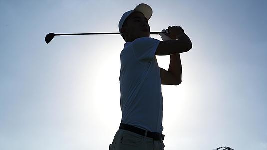 阳光下打高尔夫的男青年视频的预览图