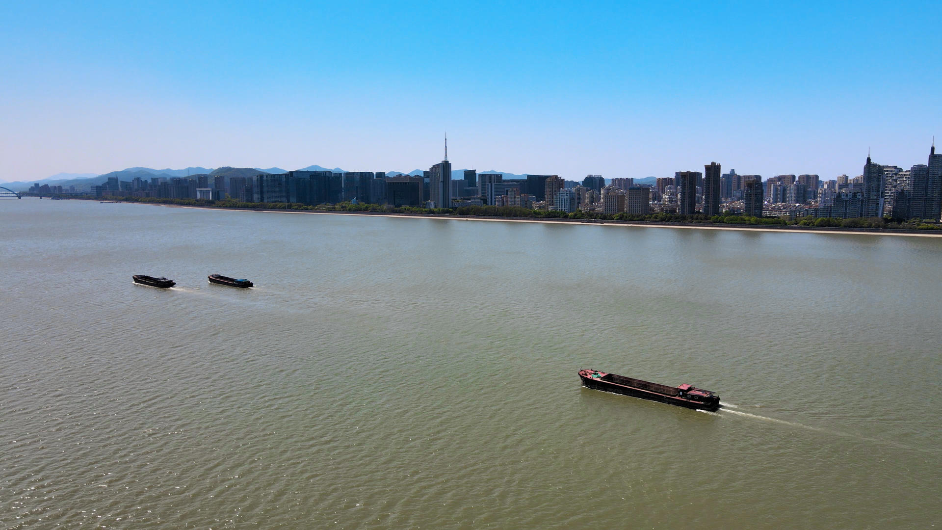 4K航拍杭州钱塘江货船运输远眺钱江新城蓝天视频的预览图