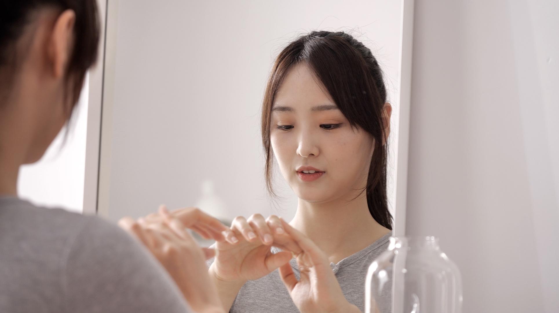 女性在镜子前擦护肤品视频的预览图