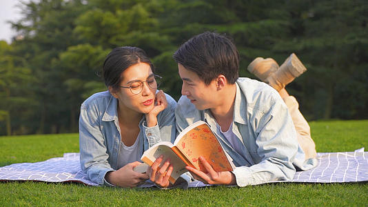 情侣在草坪上趴着看书视频的预览图