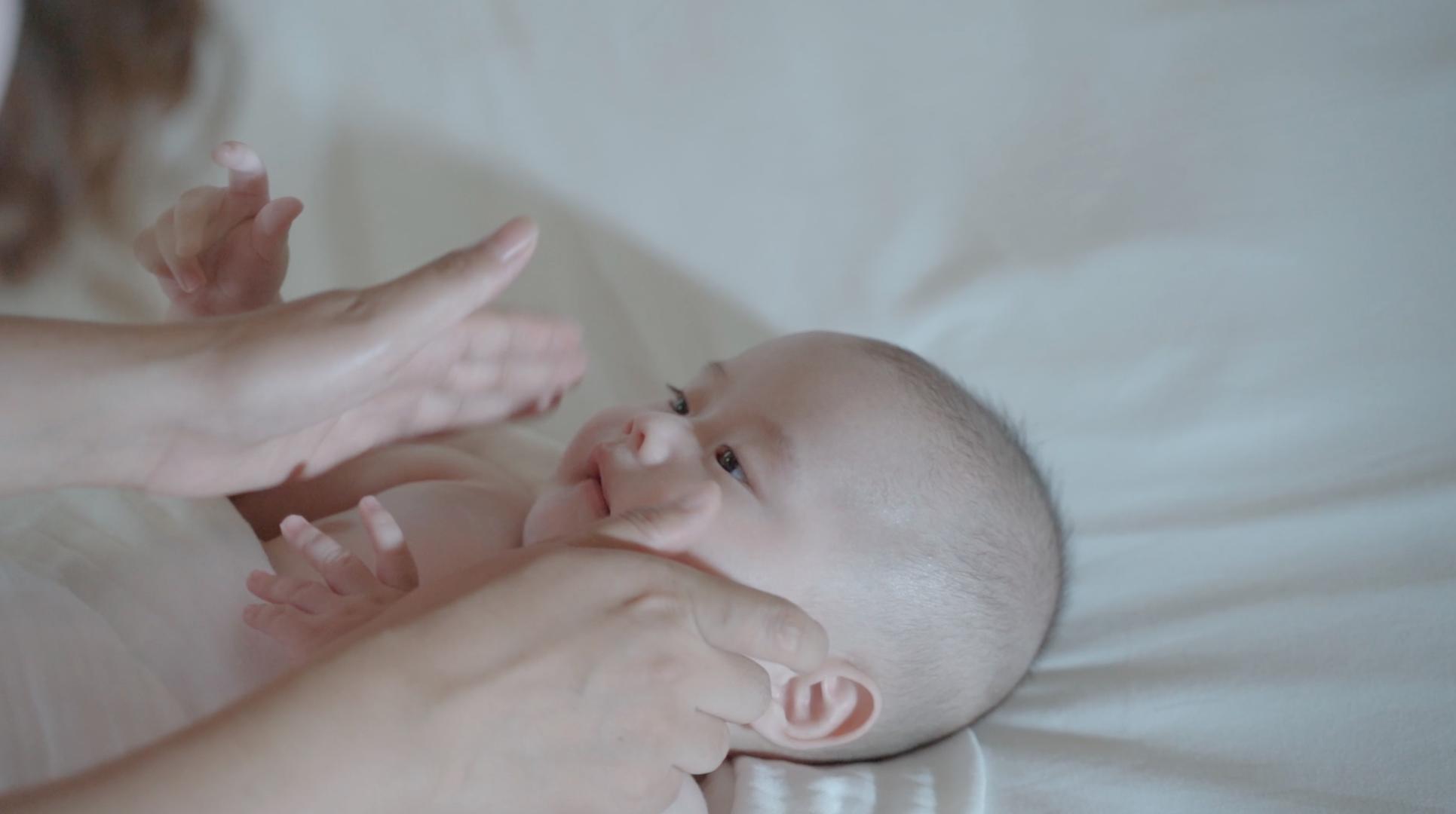 4k妈妈给婴儿宝宝按摩小脸餐身体乳视频的预览图