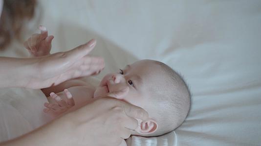 4k妈妈给婴儿宝宝按摩小脸餐身体乳视频的预览图