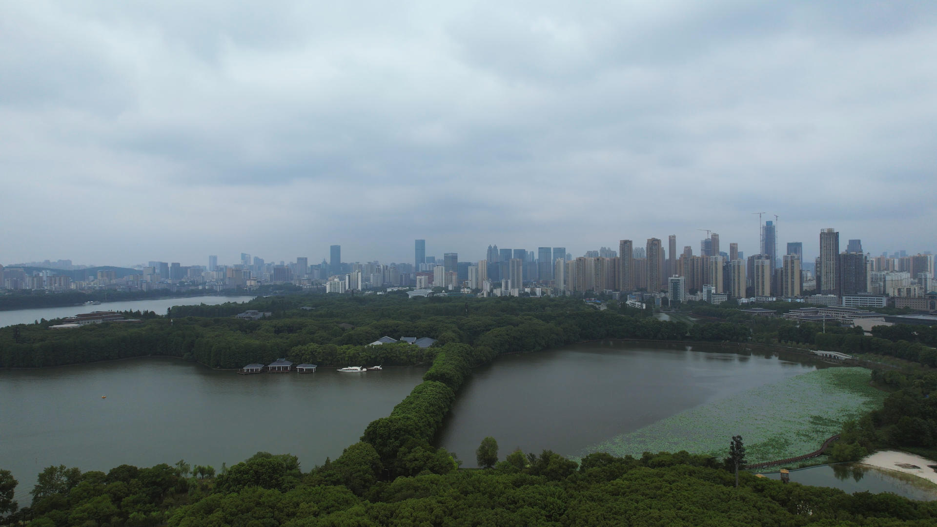 航拍暴雨来临前的城市乌云密布天空湖景绿道风景4k素材视频的预览图