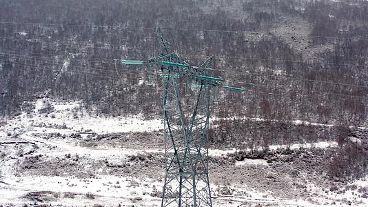 4K航拍雪景下雪天气的电力输送铁塔视频的预览图