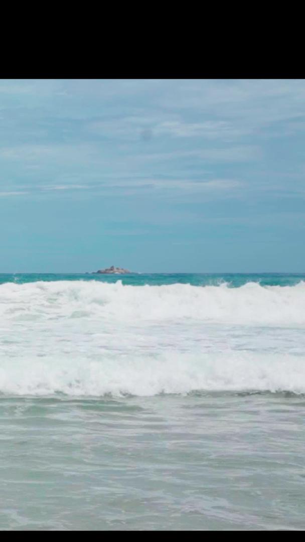 游客在海边游玩海浪度假夏海风沙滩视频的预览图