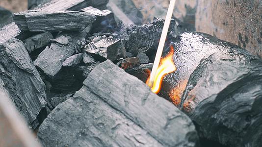 秋游野餐户外烧烤火柴点燃煤炭视频的预览图