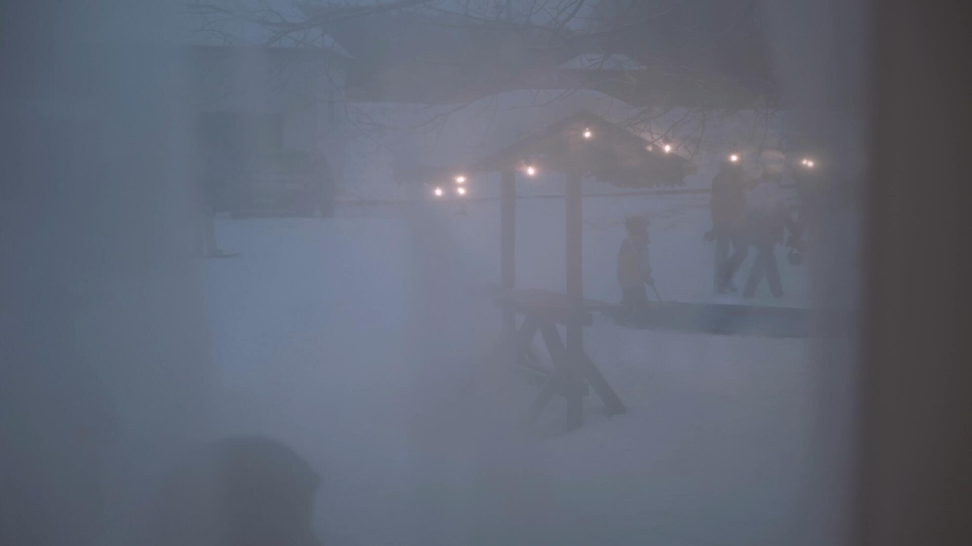 寒冬傍晚黄昏隔着窗帘拍摄户外家庭亲子雪地曲棍球游戏视频的预览图