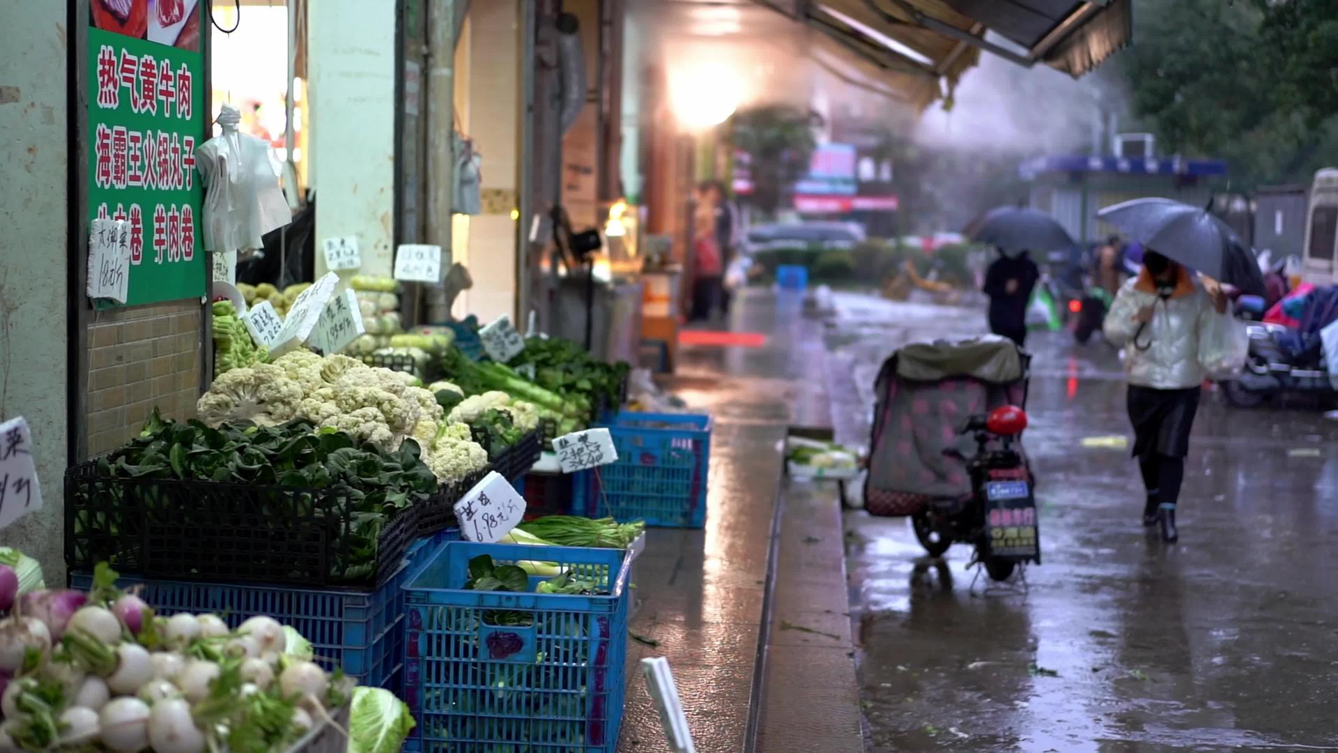 4K实拍下雨天路边菜市场人群视频的预览图
