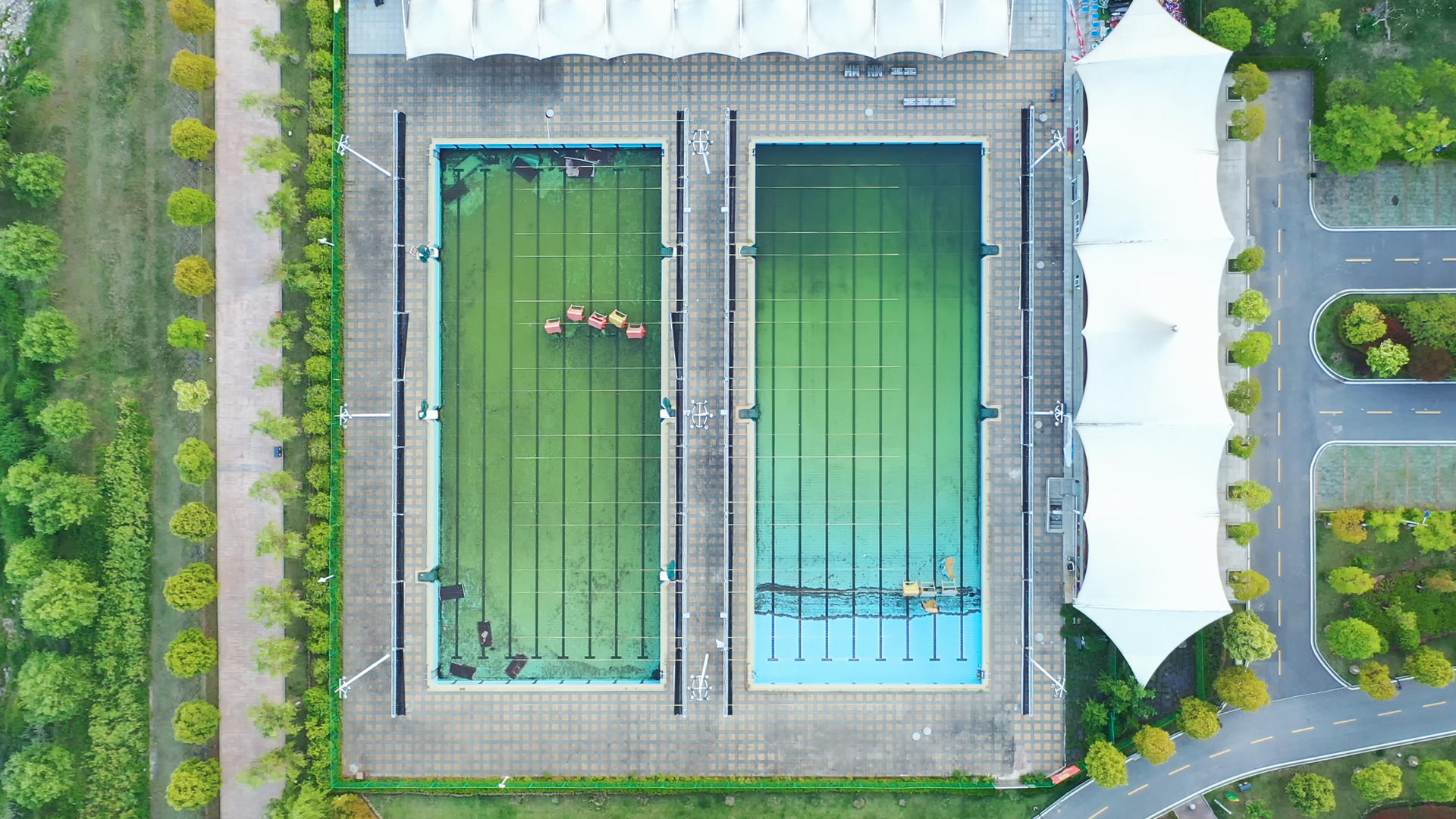航拍城市风光夏天公园游泳池运动体育场地4k素材视频的预览图