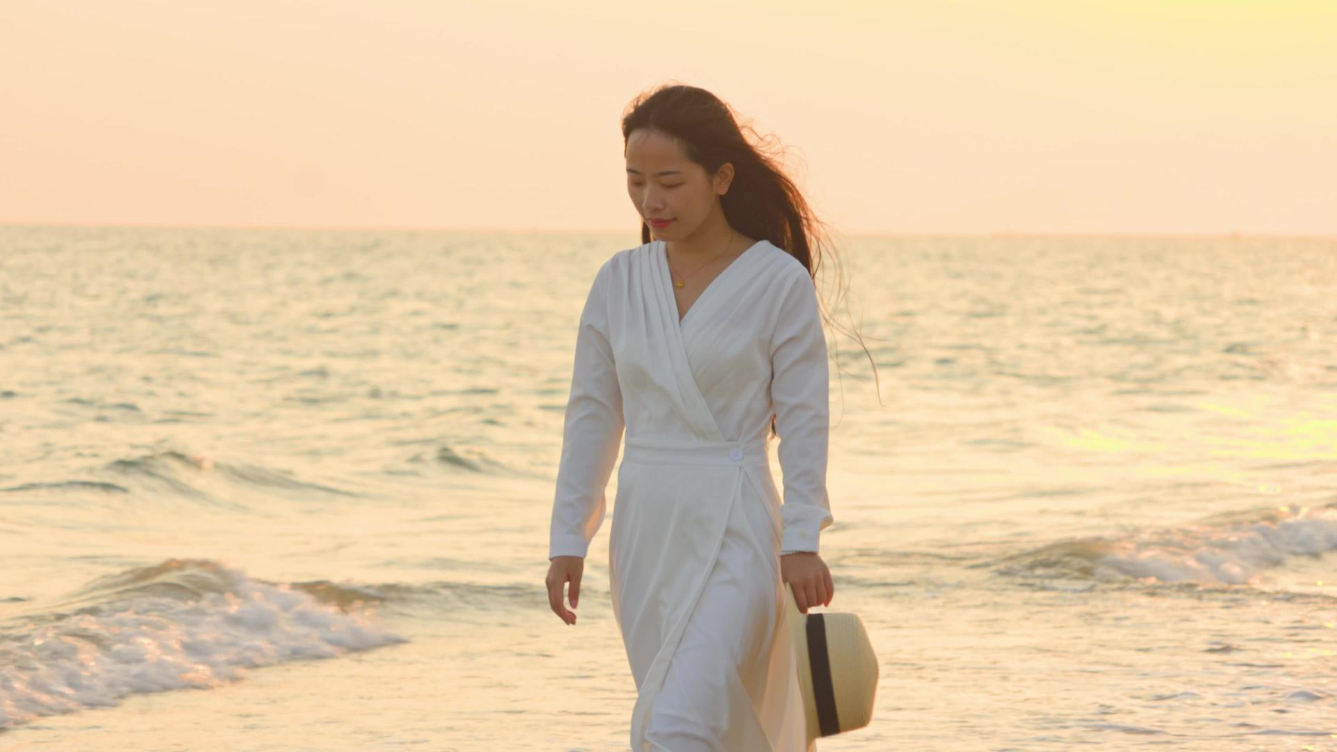 4K实拍夕阳下美女在海边休闲漫步视频素材视频的预览图
