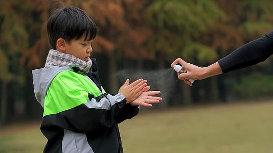 4K秋冬季小男孩疫情期间逛公园手部消毒视频的预览图