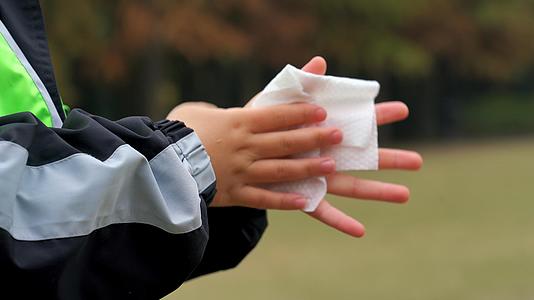 4K秋冬公园小男孩手部消毒完使用纸巾擦拭特写视频的预览图