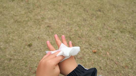 4K秋冬季节户外小男孩使用纸巾擦拭手部视频的预览图