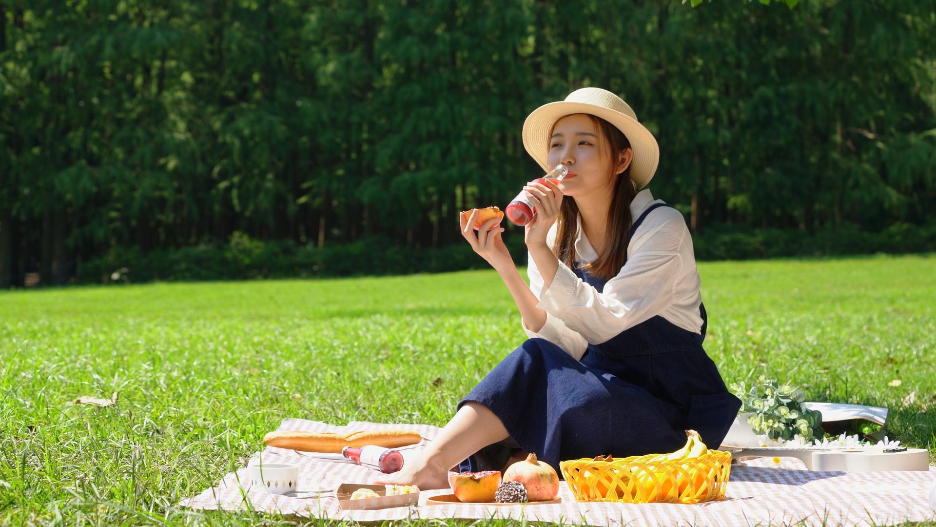 野餐垫上吃石榴的女青年视频的预览图