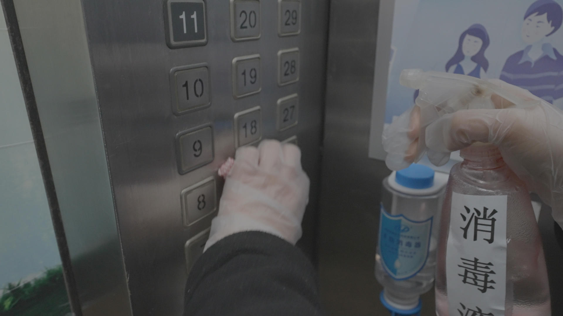 疫情防控志愿者对社区公共区域电梯按键预防性消毒4k素材视频的预览图