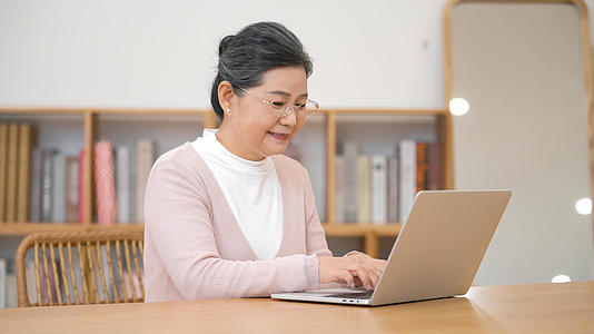 4k老年人居家生活使用笔记本电脑打字沟通娱乐视频的预览图