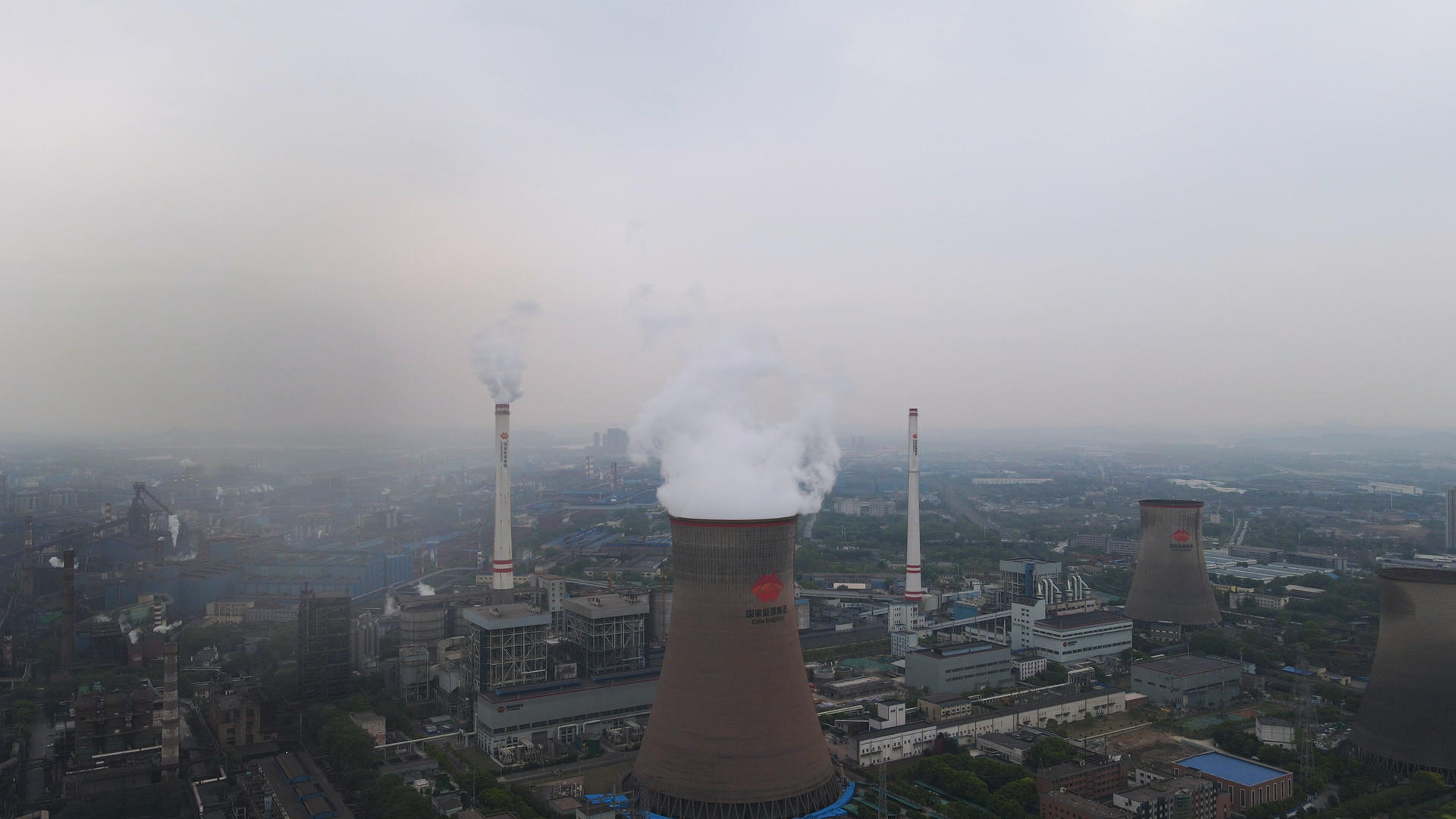 航拍城市现代化工业工厂冷凝塔排放白色烟雾4k素材视频的预览图