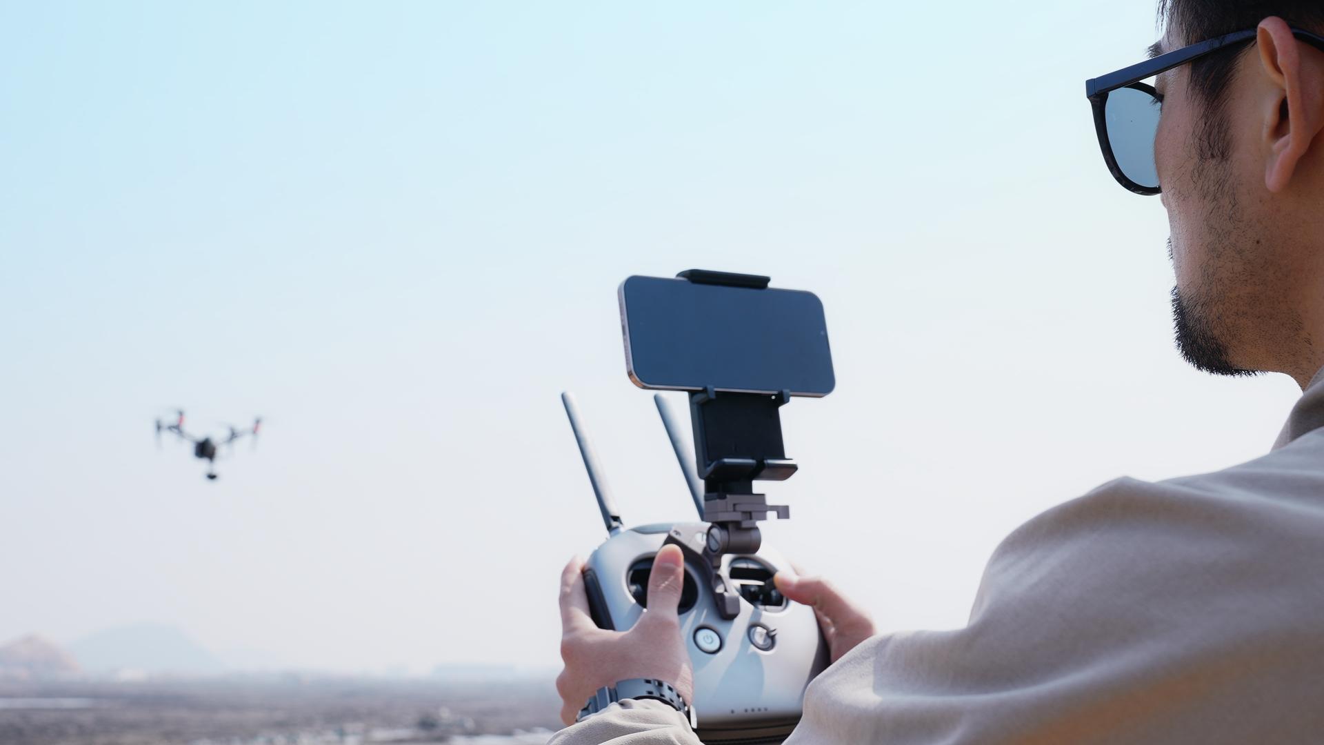 户外航拍摄影师操控无人机遥控器视频的预览图