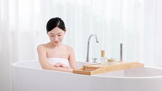 女生走进浴缸在涂抹乳液视频的预览图