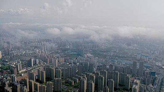 4K航拍平流雾云端之下的城市风光和建筑群视频的预览图