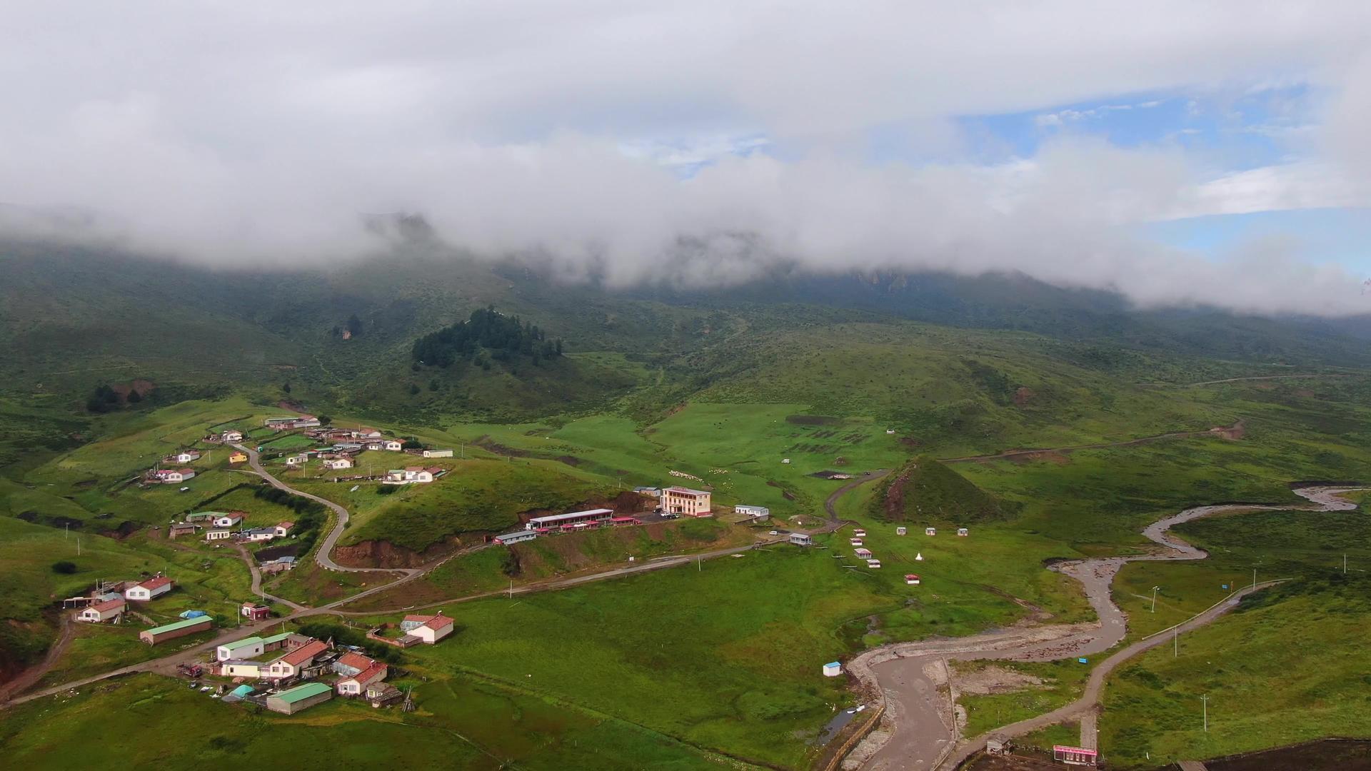 云雾缭绕的雪山脚下散落的村庄航拍视频视频的预览图