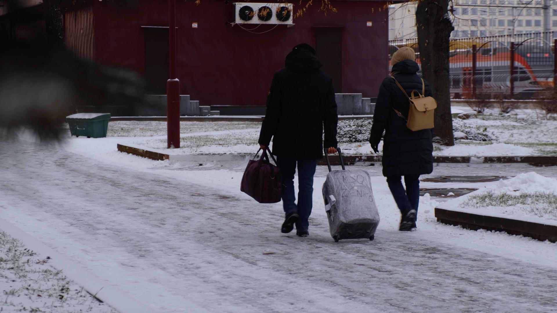 冬天下雪天气拉着行李箱出行的人们视频的预览图
