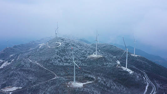 4K航拍宏伟大气雪山之巅风力发电机大风车自然风光视频的预览图