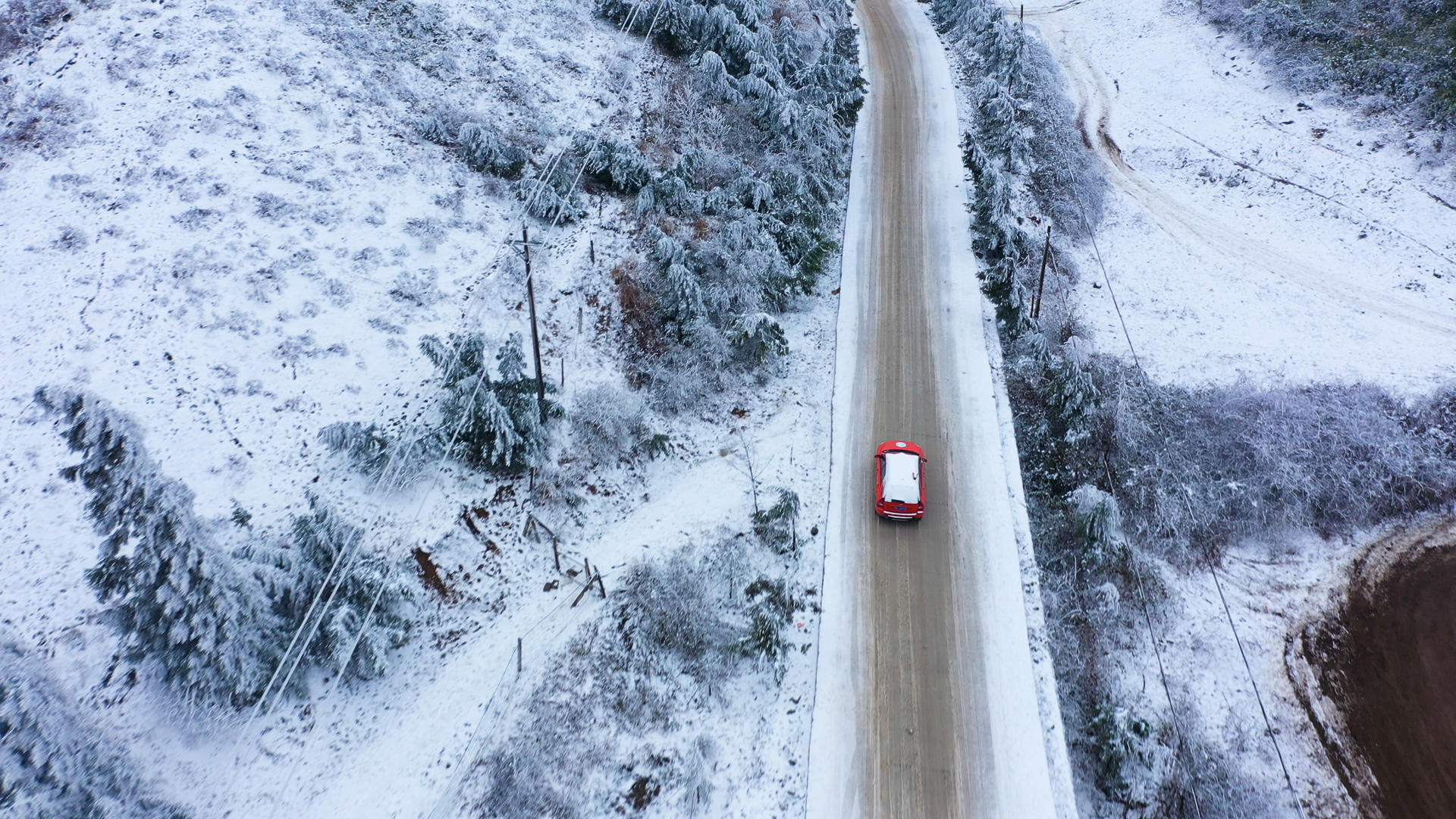 4K航拍雨雪天气下汽车行驶在积雪路面视频的预览图