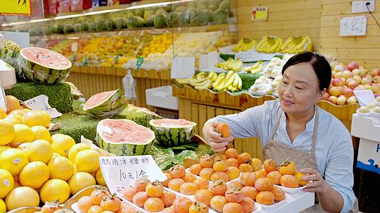 店员大妈检查摆放好的柿子是否完好视频的预览图