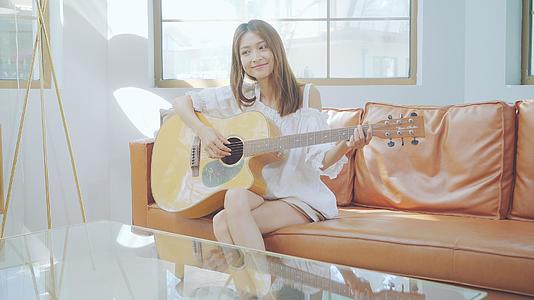 4K女生在沙发上弹吉他视频的预览图