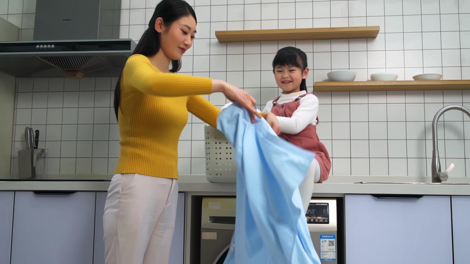 母女在洗衣房整理衣服视频的预览图