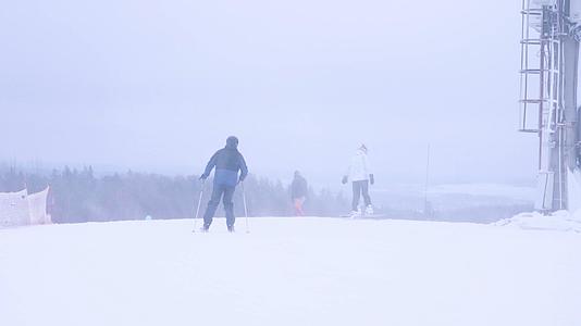 寒冬暴风雪滑雪运动场双板滑雪的人视频的预览图