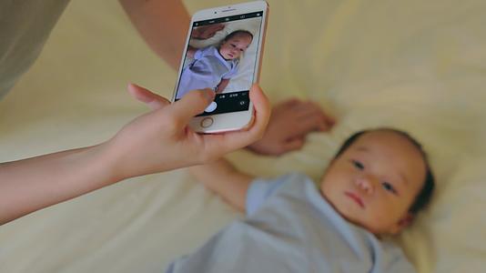 宝妈用手机给宝宝拍照视频的预览图
